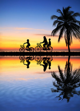silhouette happy family  ride bike on sunrise