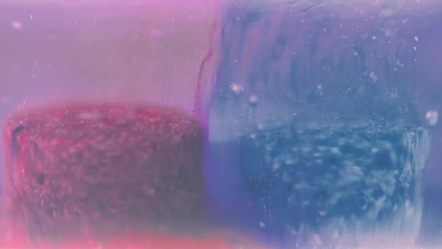 Drug laboratory concept. Blue and red pill dissolving in clear liquid. 