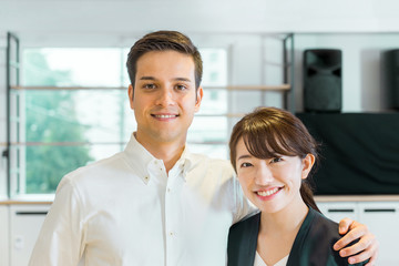 笑顔で肩を組む男性と女性（人種の違う人々）
