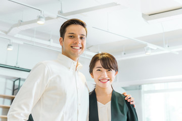 Obraz premium 笑顔で肩を組む男性と女性（人種の違う人々）