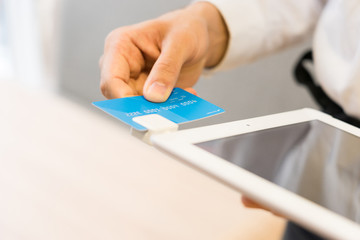 タブレット端末でカード決済をする店員