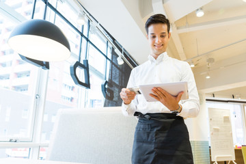 タブレット端末でクレジットカード決済をする男性の店員