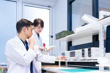 実験室で研究開発・解析・調査をする白衣の男性と女性