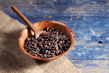 Coffee beans in wooden cup on rustic wooden table with a blank space for a text, Coffee in cup on loft background