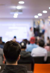 Presenter at corporate conference giving speech. Speaker giving lecture to business audience in...