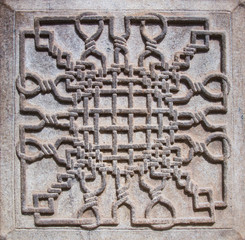 A decorative stone carving a decorative group of knots.