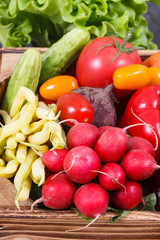 Fresh ripe vegetables in wooden box as healthy snack containing vitamins