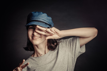 Naklejka premium portrait of a brunette in a gray t-shirt and blue denim cap