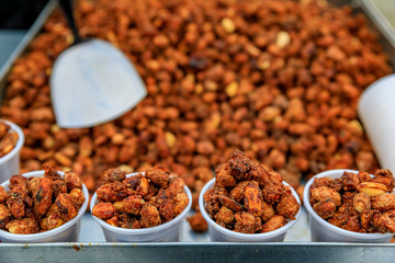London street food - roasted caramelized peanuts in plastic cups on a cart on a bridge in London, England, UK