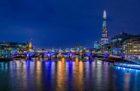 London, England skyline at night with the Shard, Southwark Bridge and Tower Bridge on Thames river with night lights