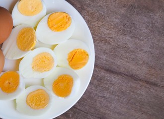Sliced boiled eggs on wood table background.