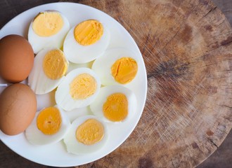 Sliced boiled eggs on wood table background.