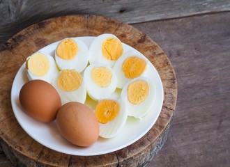 Sliced boiled eggs on wood table background.
