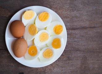 Sliced boiled eggs on wood table background.