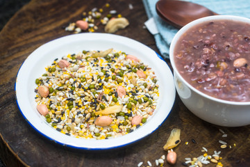 The white container holds the raw material of the eight treasures grain porridge on the board
