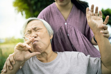 Asian senior mother holding a cigarette smoking,female old in wheelchair smoking near daughter,woman request elderly people to stop smoking,bad smell,pollution from cigarettes smoke,health care,life