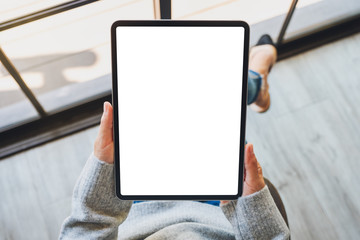 Top view mockup image of a woman holding black tablet pc with blank white screen