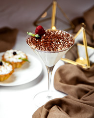 italian tiramisu in martini glass topped with coffee sprinkles and strawberry