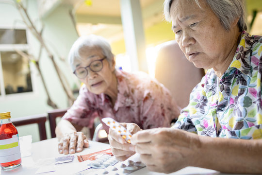 Asian Female Senior Hold Medicine Pill,elderly Woman Consult Her Old People Friend,help And Read Medicine Labels Drug Prescription,discussing Medication Received From The Hospital,directions Of Use