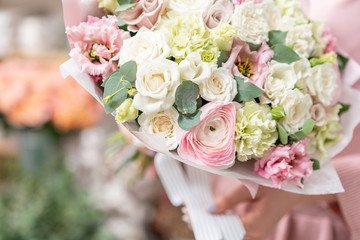 European floral shop. Beautiful bouquet of mixed flowers in womans hands. the work of the florist at a flower shop. Delivery fresh cut flower.