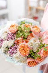 European floral shop. Beautiful bouquet of mixed flowers in womans hands. the work of the florist at a flower shop. Delivery fresh cut flower.