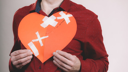 Man holding broken heart. Heartbreak