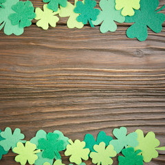 Happy Saint Patrick's mockup of handmade felt shamrock clover leaves on wooden background.