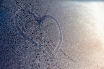 Symbol of broken heart and unrequited love. Drawn heart on cracked rainy window.