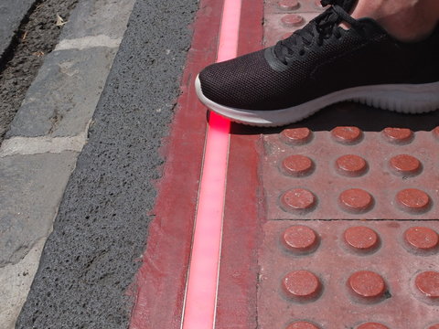 LED strip on the pedestrian road. Braille Blocks in the pedestrian guiding the blinds walks. Traffic sign for pedestrians.