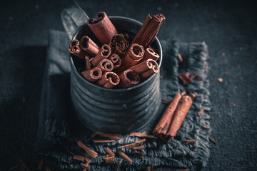 Heap of cinnamon sticks in old metal mug