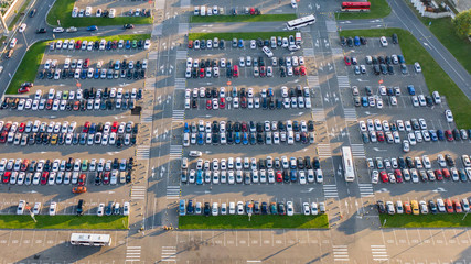 Aerial view from above. Parking at the shopping center. Lots of cars in the Parking lot. Clear sunny day.