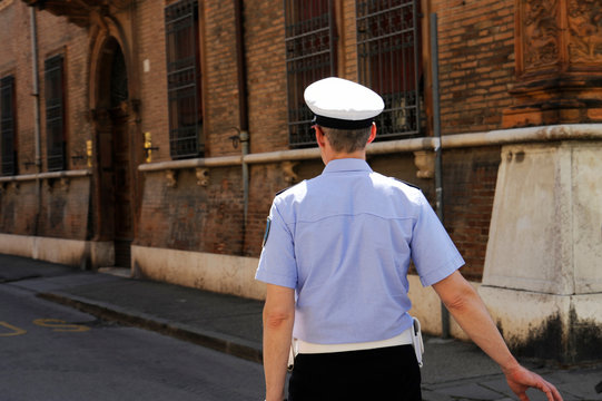 Vigile urbano dà la direzione nel centro storico della città. Ferrara, Italy