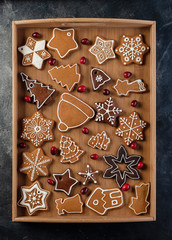 Various decorated gingerbread cookies in a wooden box