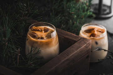 Iced coffee cocktail with milk on dark background