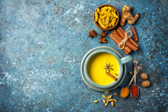 Healthy drink of golden turmeric milk with spices