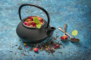 Black japanese cast iron teapot with rose tea and mint