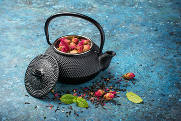 Black japanese cast iron teapot with rose tea and mint