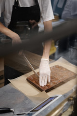 Chocolate brownie dessert with nuts. Cooking a cake in the kitchen in a restaurant or bakery. The chef creates a delicious dessert for the coffee shop.