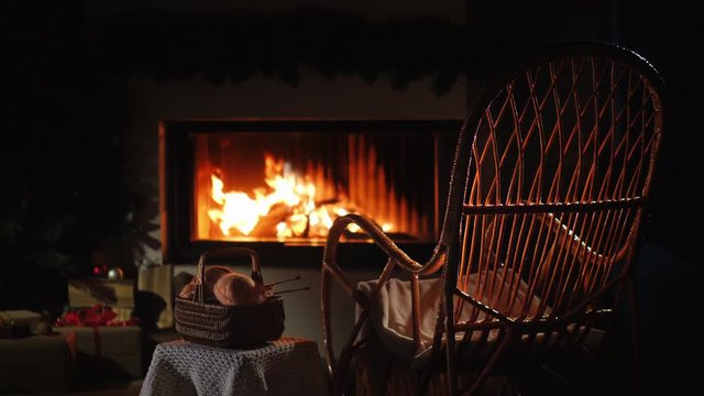 Rocking chair and a set for knitting by the fireplace. Nice evening at home