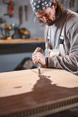 Carpenter working on a old wood in a retro vintage workshop.