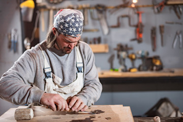 Carpenter working on a old wood in a retro vintage workshop.