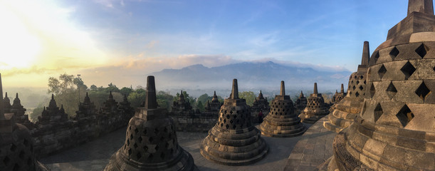 Panorama of Borobudur sacred temple, stuning ancient temple with black stone bells (stupa) in...