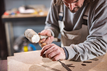 Carpenter working on a old wood in a retro vintage workshop.