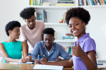 Successful african american female student learning at desk at school