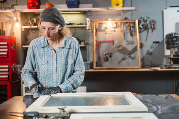 Carpenter working on the old wood in a retro vintage workshop.