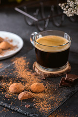Chocolate truffle candy with cocoa powder on dark background