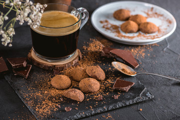 Chocolate truffle candy with cocoa powder on dark background
