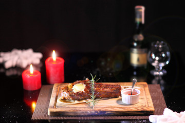 Rib eye steak on the christmas table. Steak rib eye roast on a wooden board with sauce and salt. Beef steak on wooden plate.