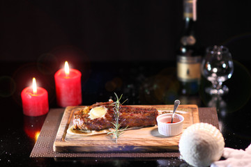 Rib eye steak on the New Year's table. Steak rib eye roast on a wooden board with sauce and salt. Beef steak on wooden plate.