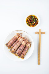 Steamed crusty shrimp and seasoning sauce on a plate on white background